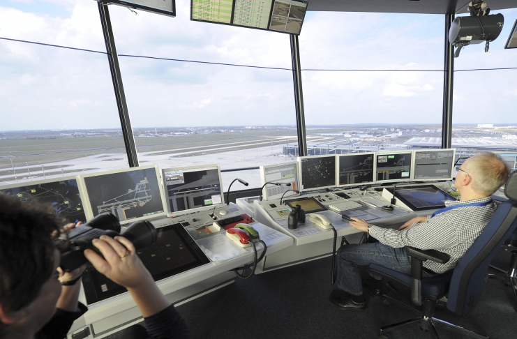 An air traffic controllers watch from inside the new tower of the future Berlin Brandenburg Airport in Schoenefeld