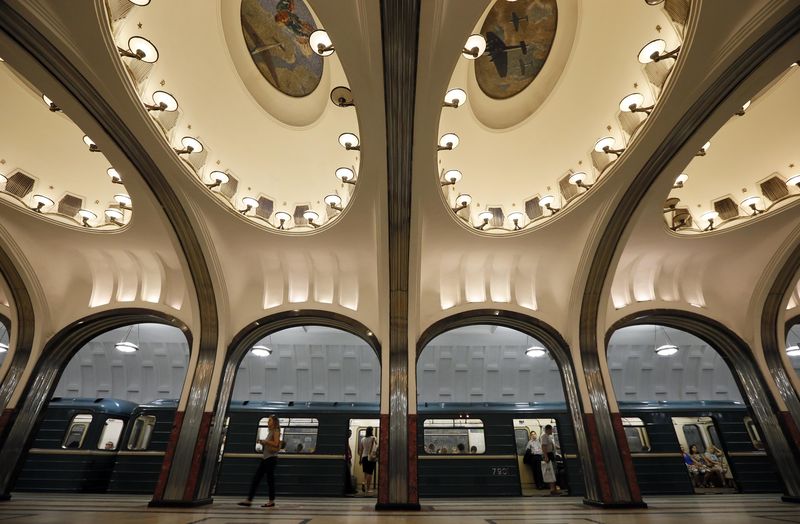 A woman walks on the platform as a train arrives at Mayakovskaya metro station, which was built in 1938, in Moscow