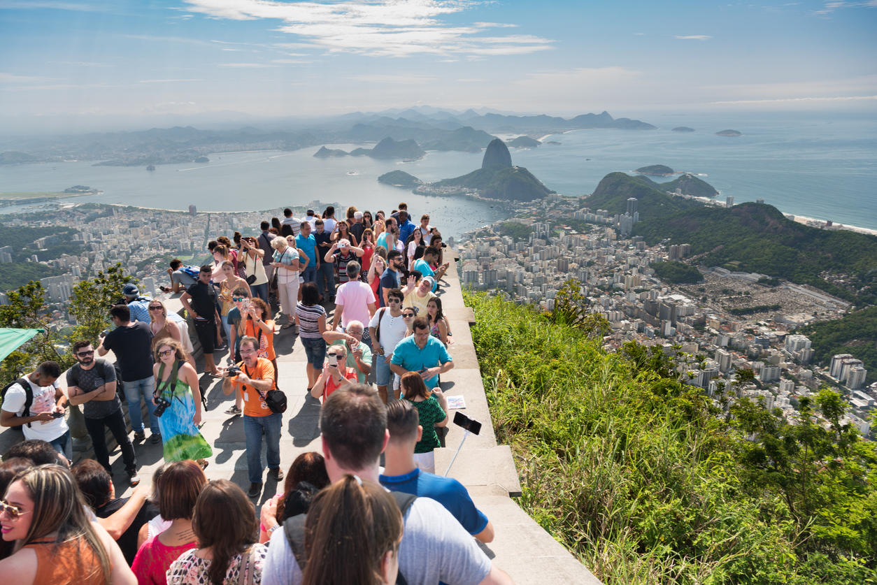 Crowd of Tourists at the Christ the Redeemer Statue viewing platform overlooking Sugarloaf Mountain and Rio, Brazil