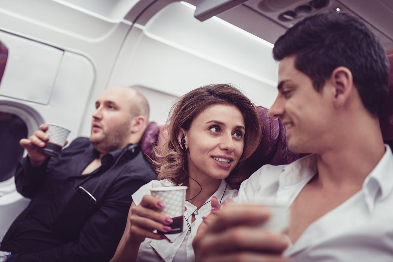 Cute Couple Talking and Drink Coffee in the Airplane