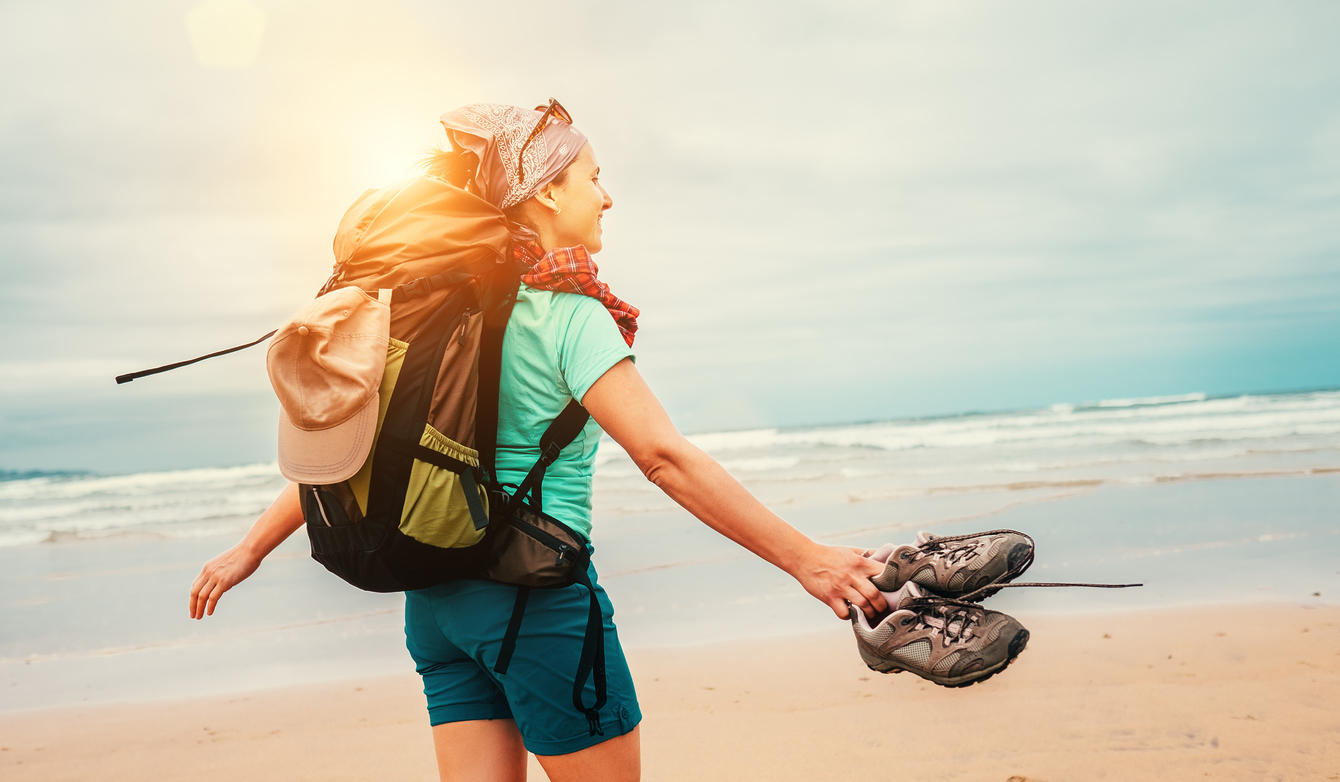 Girl backpacker traveler enjoys with fresh ocean wind