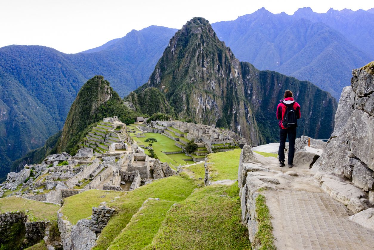 Woman overlooking the Inca ruins of Machu Picchu