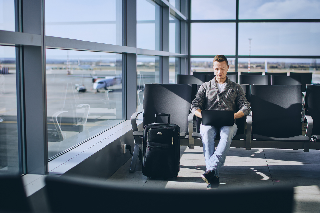 Traveler using laptop in airport terminal