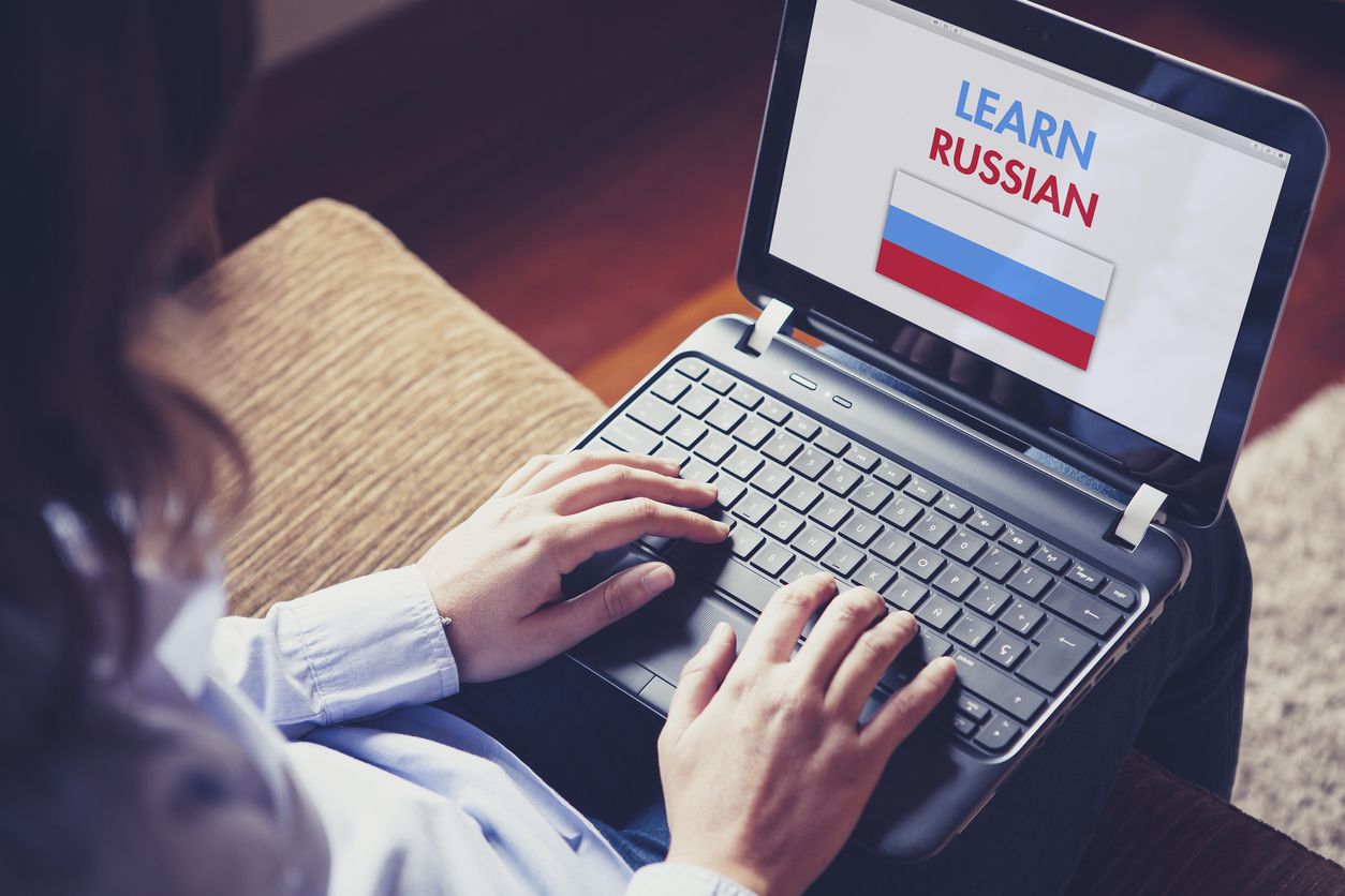 Female learning russian at home with a laptop.